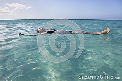 Woman floating and relaxing in the sea Stock Photo