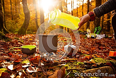 Woman flow water from collapsible bottle to a portable pan Stock Photo