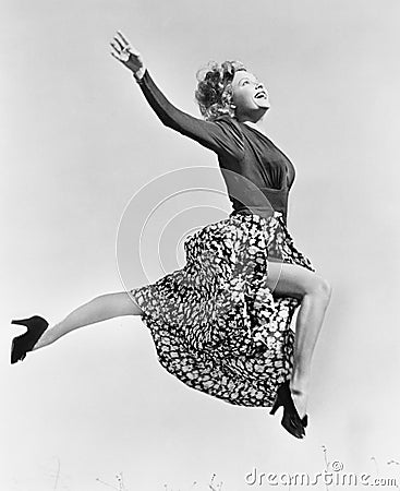 Woman in a flowing skirt leaping through the air Stock Photo