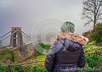 Woman in focus looking at famous Clifton bridge in Bristol England Editorial Stock Photo