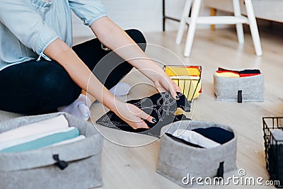 Woman folding clothes on the floor, organizing stuff and laundry Stock Photo