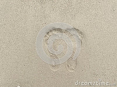 Woman footprint stamp on sand ground at the beach. Rough surface texture. Stock Photo