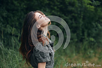 Woman in the forest looking up with closed eyes smile freedom fresh air background nature Stock Photo