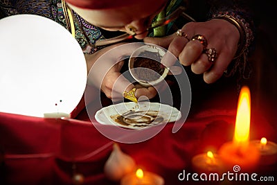 Woman fortune teller looking in empty coffee cup Stock Photo