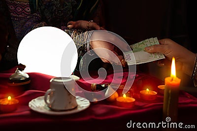 Woman fortune teller receive money from another woman Stock Photo