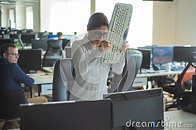 A woman freaks out and gets depressed from a mistake and breaks the keyboard on the monitor. Female manager gets angry Stock Photo