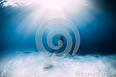 Woman freediver in bikini over sandy sea with fins. Freediving underwater Stock Photo