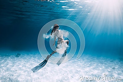 Woman freediver with fins and white sand over sandy sea. Freediving underwater Stock Photo