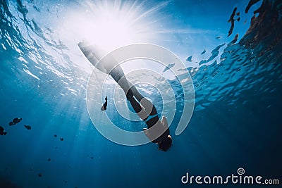 Woman freediver relax with fins underwater. Freediving girl and beautiful light in blue sea Stock Photo