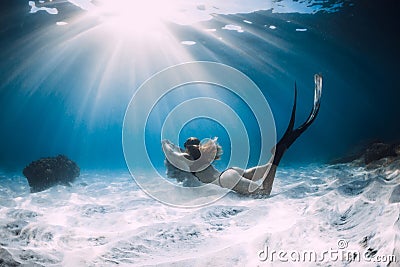 Woman freediver with white sand over sandy sea with fins. Freediving underwater Stock Photo