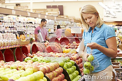 Woman At Fruit Counter In Supermarket Stock Photo