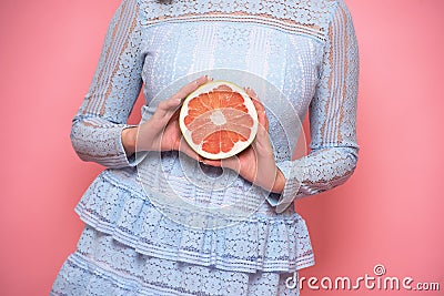 Woman fruit diet and healthy food eating concept. Girl holds grapefruit in hands. Stock Photo