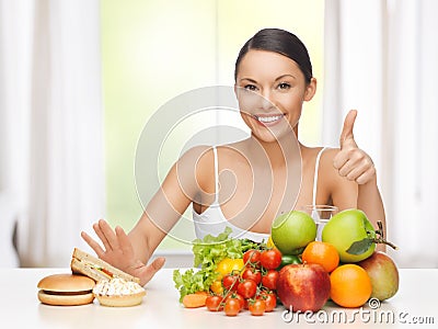 Woman with fruits rejecting junk food Stock Photo