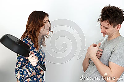 Woman with frying pan scolding on drunk man Stock Photo