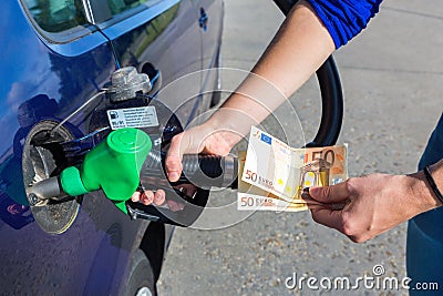 Woman fueling car tank and holding euro money Stock Photo