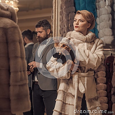 Woman in fur coat with man, shopping, seller and customer. Stock Photo