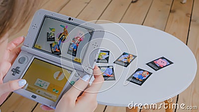 Woman gamer using game console Nintendo 3ds with AR app Editorial Stock Photo