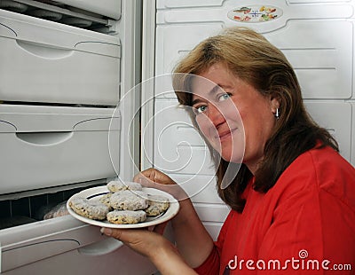 Woman gets out of refrigerator frozen meatba Stock Photo