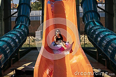 Woman getting down by the slide in aqua park Stock Photo