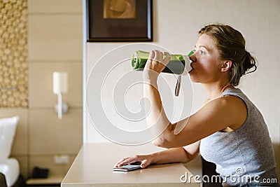 Woman getting having her green smoothie after training. Stock Photo