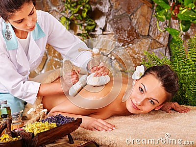 Woman getting thai herbal compress massage . Stock Photo