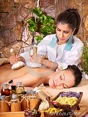 Woman getting thai herbal compress massage . Stock Photo