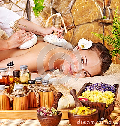 Woman getting thai herbal compress massage . Stock Photo