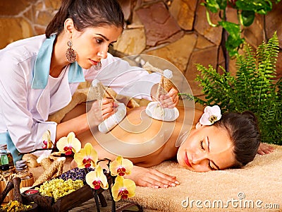 Woman getting thai herbal compress massage . Stock Photo