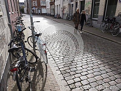 Woman and girl pass a lot of parked bicycles in the centre of old dutch city groningen Editorial Stock Photo