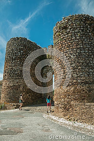 Woman and girl passing through the main doorway of Evoramonte Editorial Stock Photo