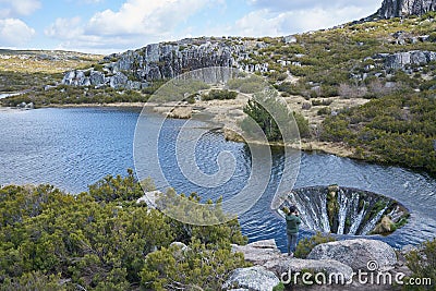Woman girl taking photos of Covao dos Conchos lagoon in Serra da Estrela, Portugal Stock Photo