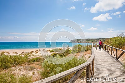 Woman and girl walking on footbridge on beach in Cadiz Stock Photo