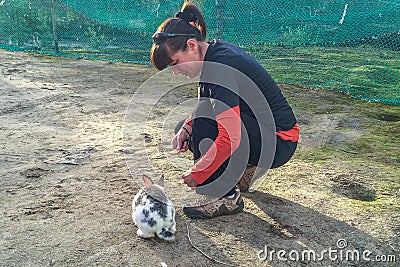 Woman gives food to rabbit. Nature love and vegan concept Stock Photo