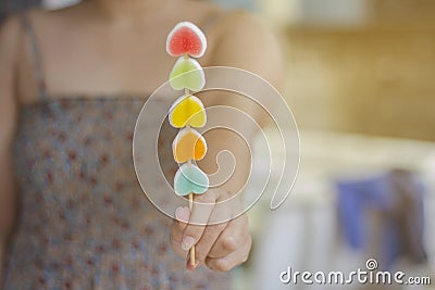Woman giving juicy gummy candies into a heart shape for the day of love Stock Photo