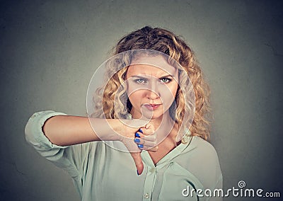 Woman giving thumb down gesture looking with negative expression Stock Photo