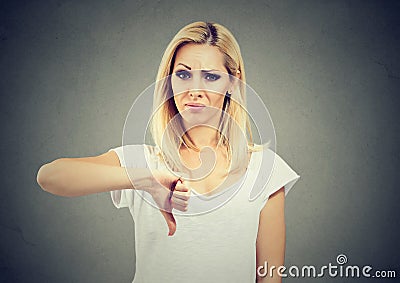 Woman giving thumb down gesture looking with negative expression and disapproval Stock Photo