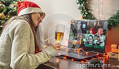 Woman with a glass of champagne is remotely communicating with friends or family via video link. Concept of party online Stock Photo