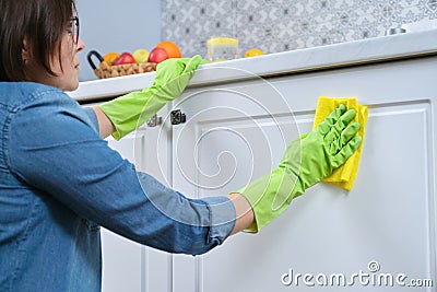Woman in gloves with rag washing, cleaning, polishing furniture doors Stock Photo