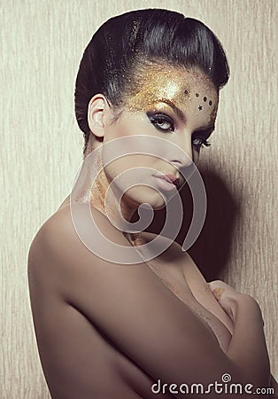 Woman with golden artistic make-up Stock Photo