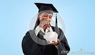 Woman, graduation and piggy bank in studio, saving and cash for investing, future or goals by blue background. Student Stock Photo