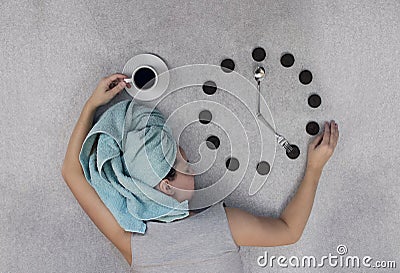 Woman on a gray background lies and keeps a Cup of coffee and a Stock Photo