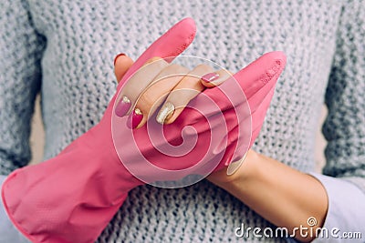 Woman in a gray sweater and bright manicure wearing pink rubber Stock Photo