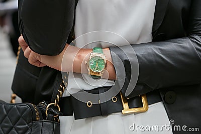 Woman with green and gold Rolex Daydate watch before Emporio Armani fashion show, Milan Fashion Editorial Stock Photo