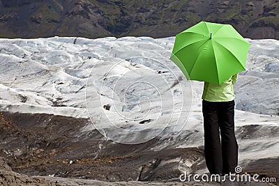 Woman With Green Umbrella By Glacier Stock Photo