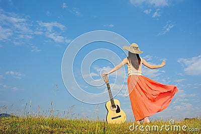 Woman and guitar standing on guitar with Cloud sky Stock Photo