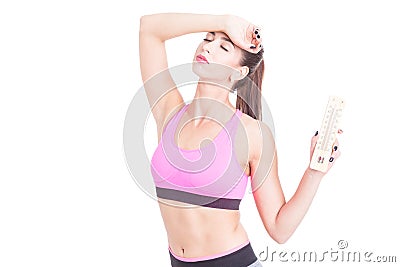 Woman at gym holding thermometer like summer heat Stock Photo