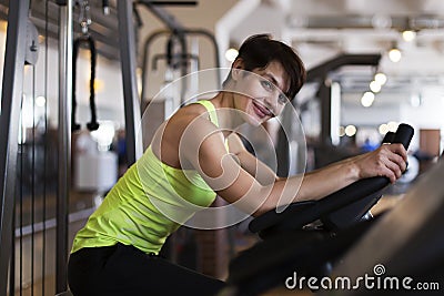 Woman in the gym on a stationary bike Stock Photo