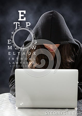 Woman hacker using a laptop in front of dark background Stock Photo