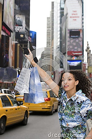 Woman hailing yellow taxi cab Stock Photo