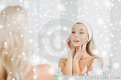 Woman in hairband touching her face at bathroom Stock Photo